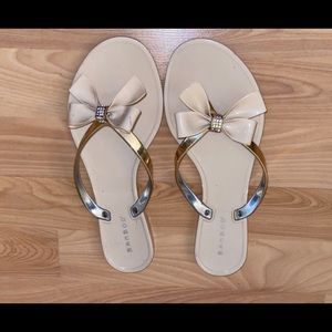 Cream flip flops with bow and gold straps